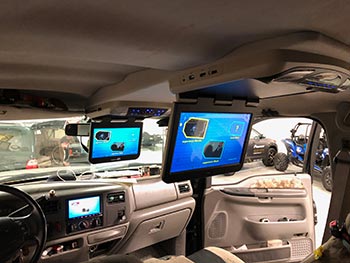 We built custom overhead console to house 10" & 13" Audiovox overhead screens in this F250. Matched console to vehicles interior. Also installed Kenwood receiver and a back up camera.