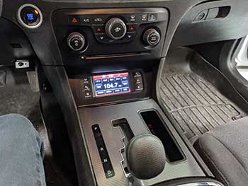 Dodge Charger. Dash modification to relocate the OEM trip computer/OEM radio to the lower console pocket.