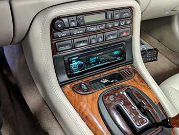 2001 Jaguar XKR. Made a custom dash kit that follows the curve of the OEM radio and console to house a Kenwood receiver. Also added satellite radio, steering wheel controls and a Kenwood 5-channel amp in the trunk.